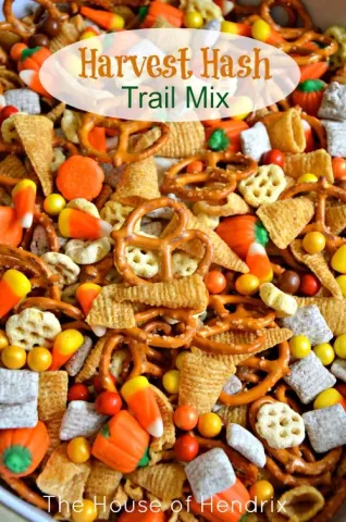 Shows an up-close picture of fall themed trail mix with candy corn, Chex mix, and more.